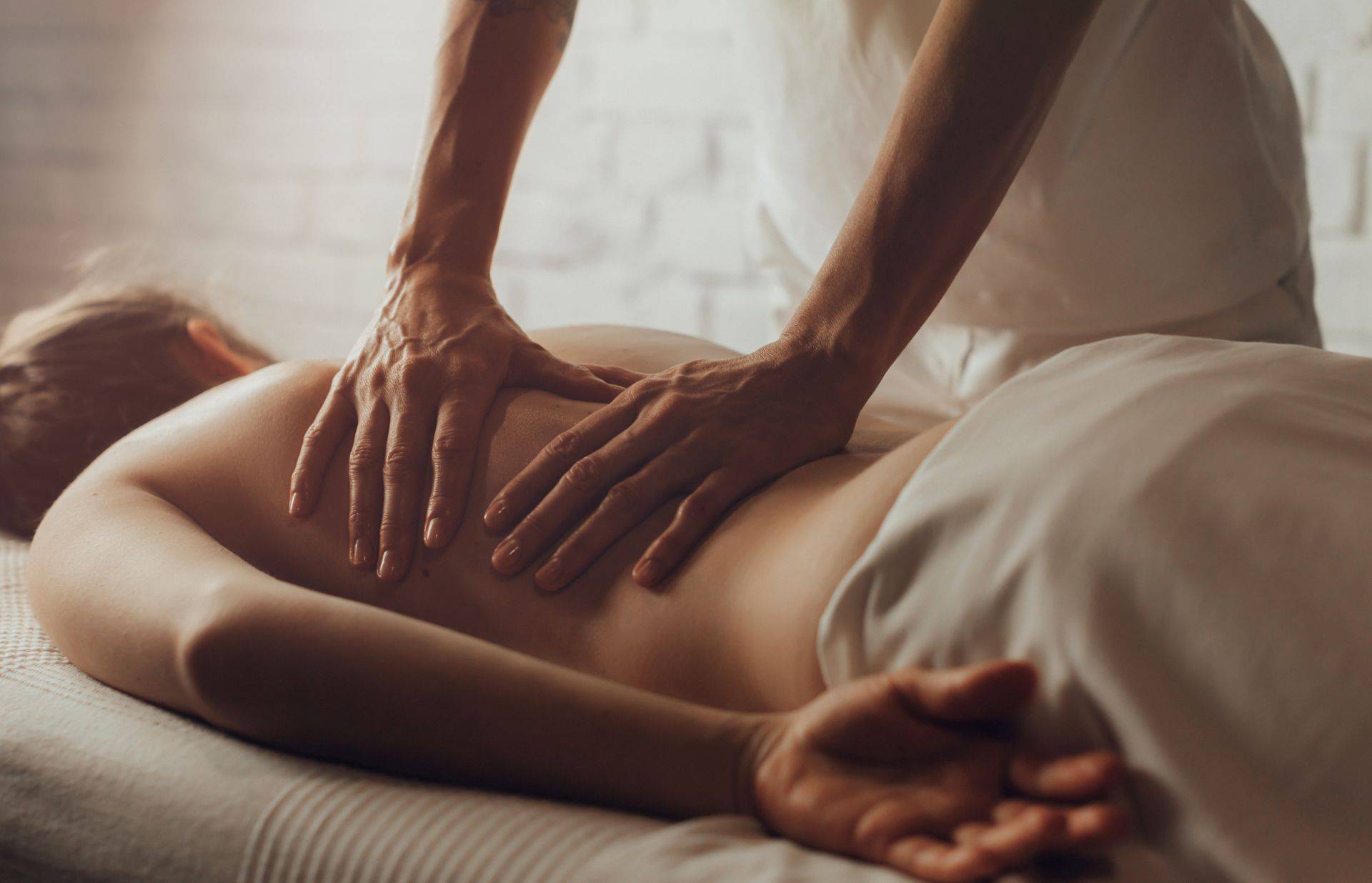 Osteopathische Behandlung: Therapeut legt beide Hände auf den Rücken eines Patienten – sanfte manuelle Therapie für mehr Wohlbefinden.