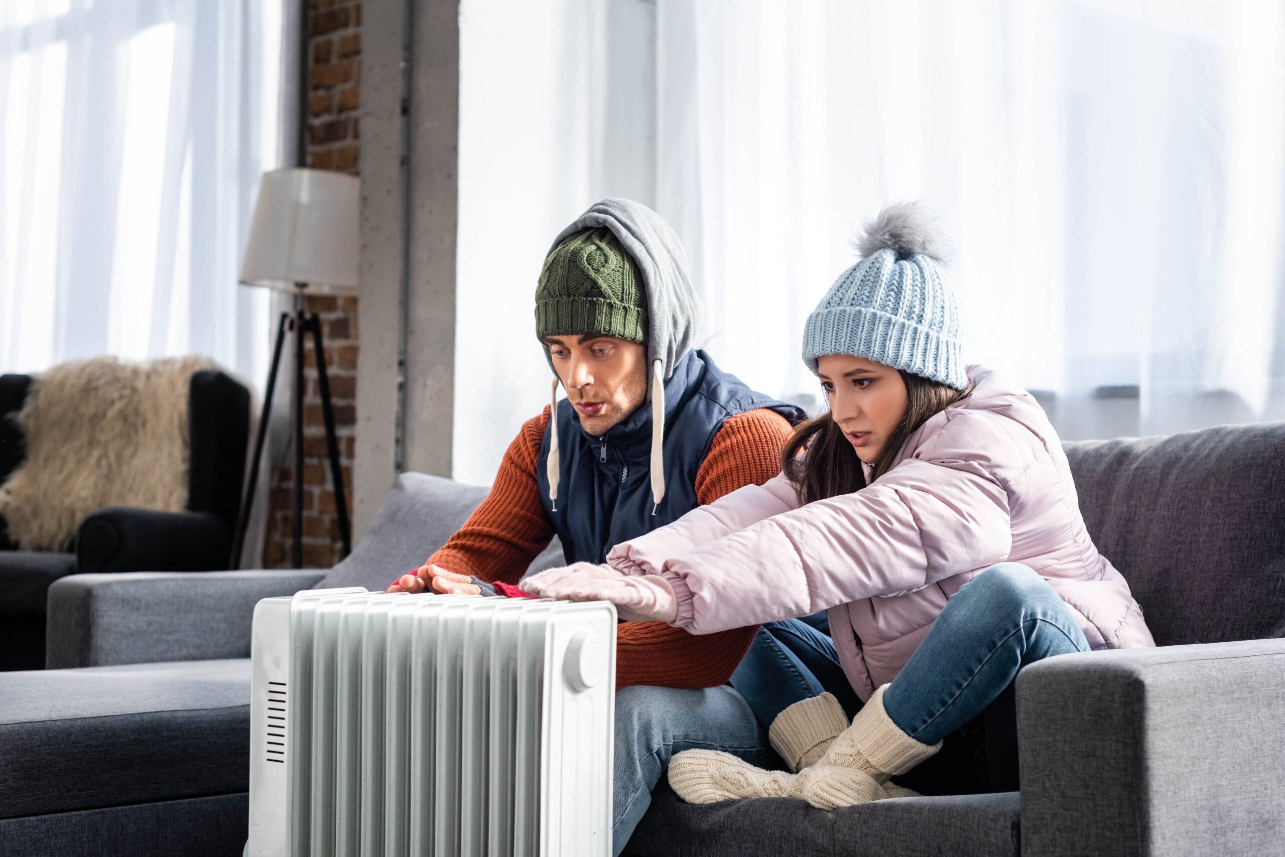 Paar wärmt sich an Elektroheizung | Heizölpreise Stuttgart